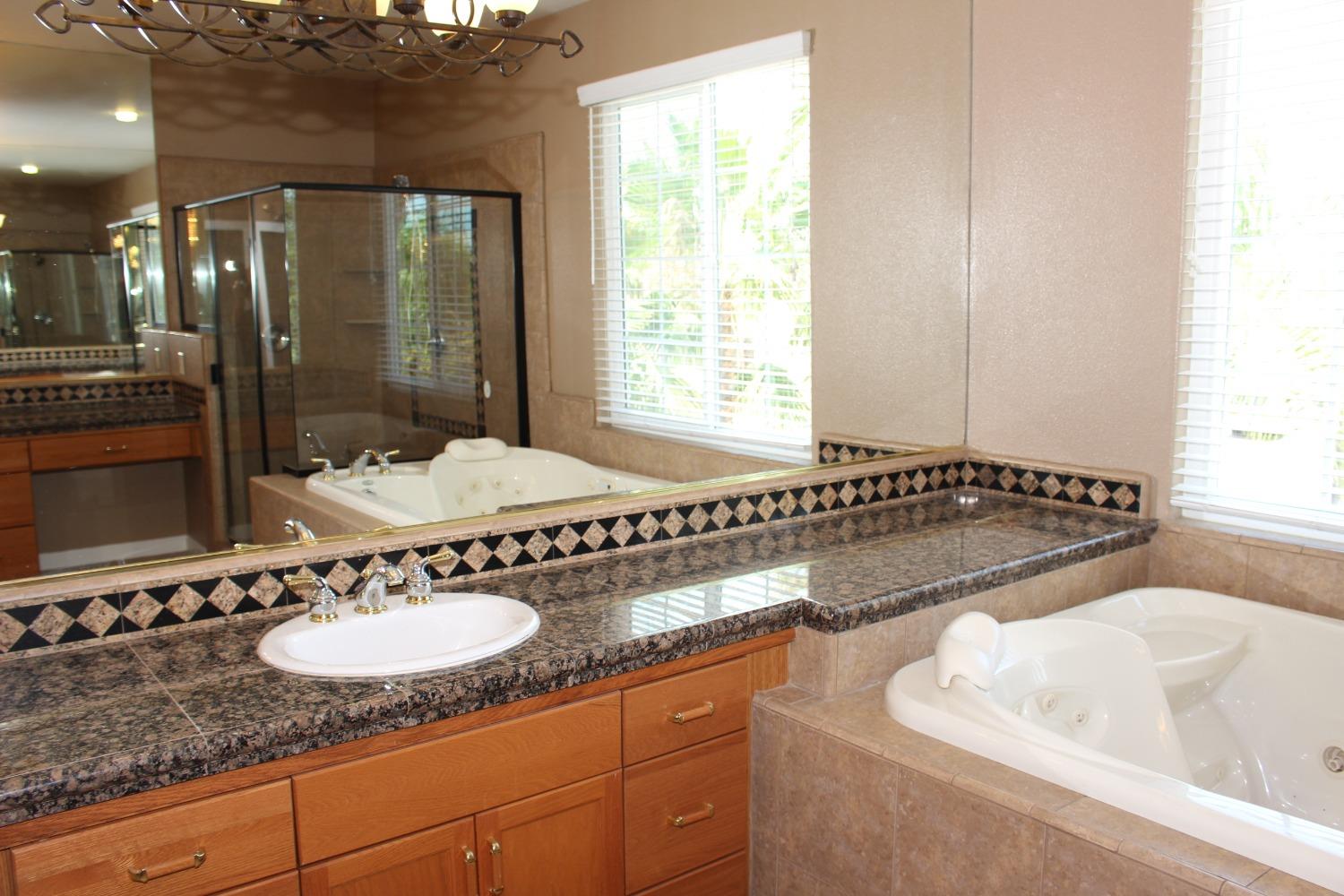 2478 Rall Avenue Clovis, CA 93611 - Photo 26 of 35 a bathroom with a granite countertop sink and a mirror