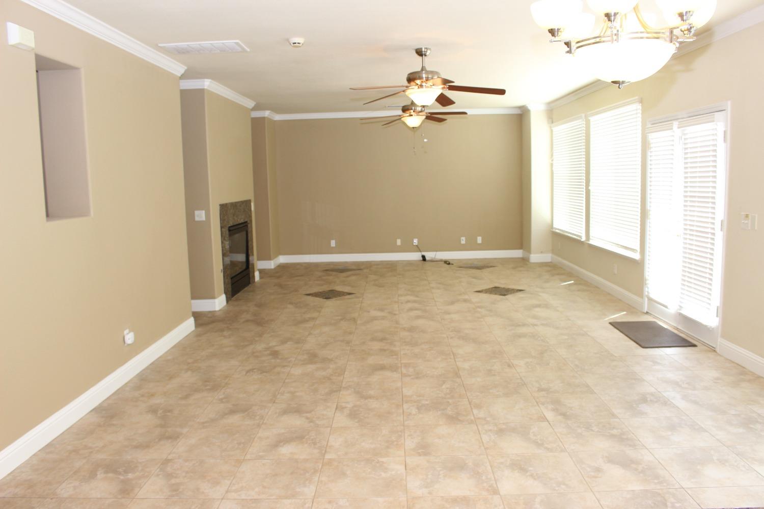 2478 Rall Avenue Clovis, CA 93611 - Photo 8 of 35 an empty room with windows and chandelier fan
