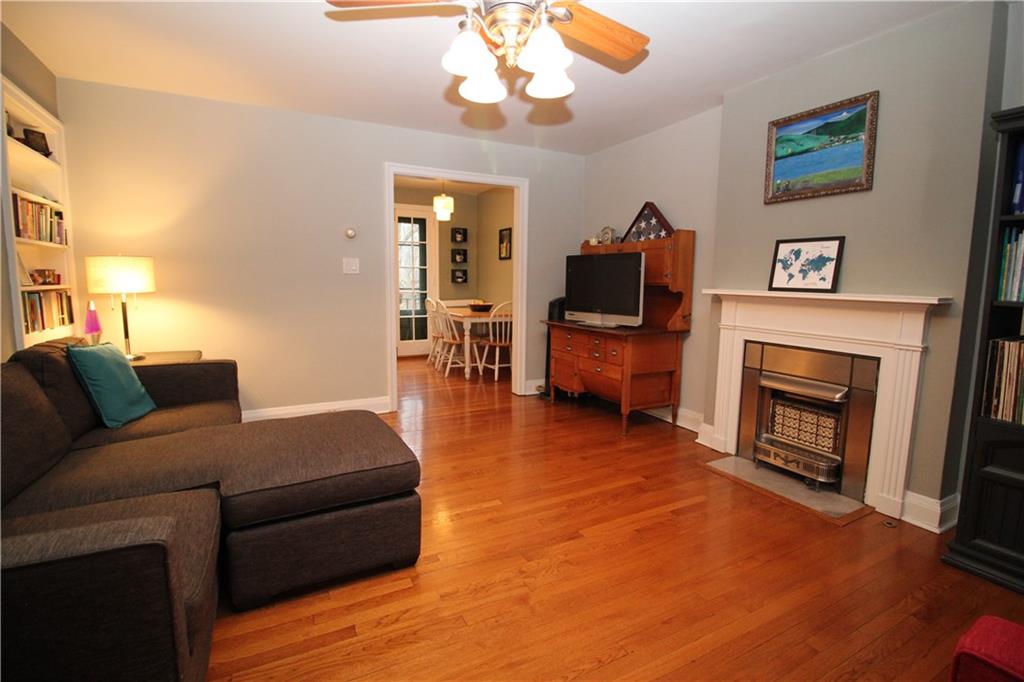 542 Bigham Road Pittsburgh, PA 15211 - Photo 4 of 25 Hardwood floors flow throughout this home. The living room includes a decorative fireplace and built-in shelving.