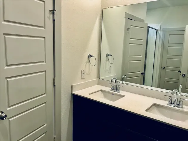 a bathroom with a sink vanity granite and a mirror