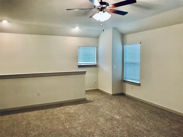 en empty room with windows and fan