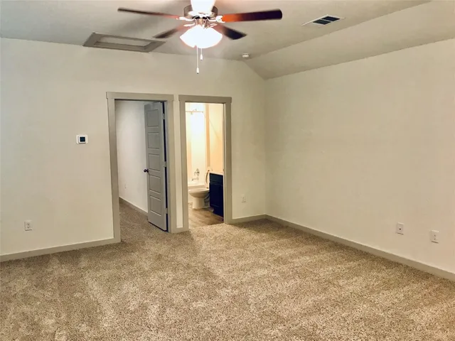 a view of an empty room with a chandelier fan