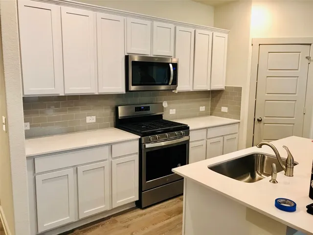 a kitchen with white cabinets and white appliances