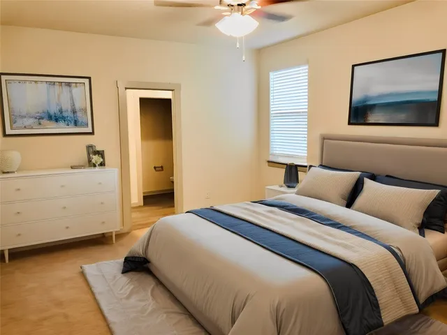 a bedroom with a large bed and a chandelier