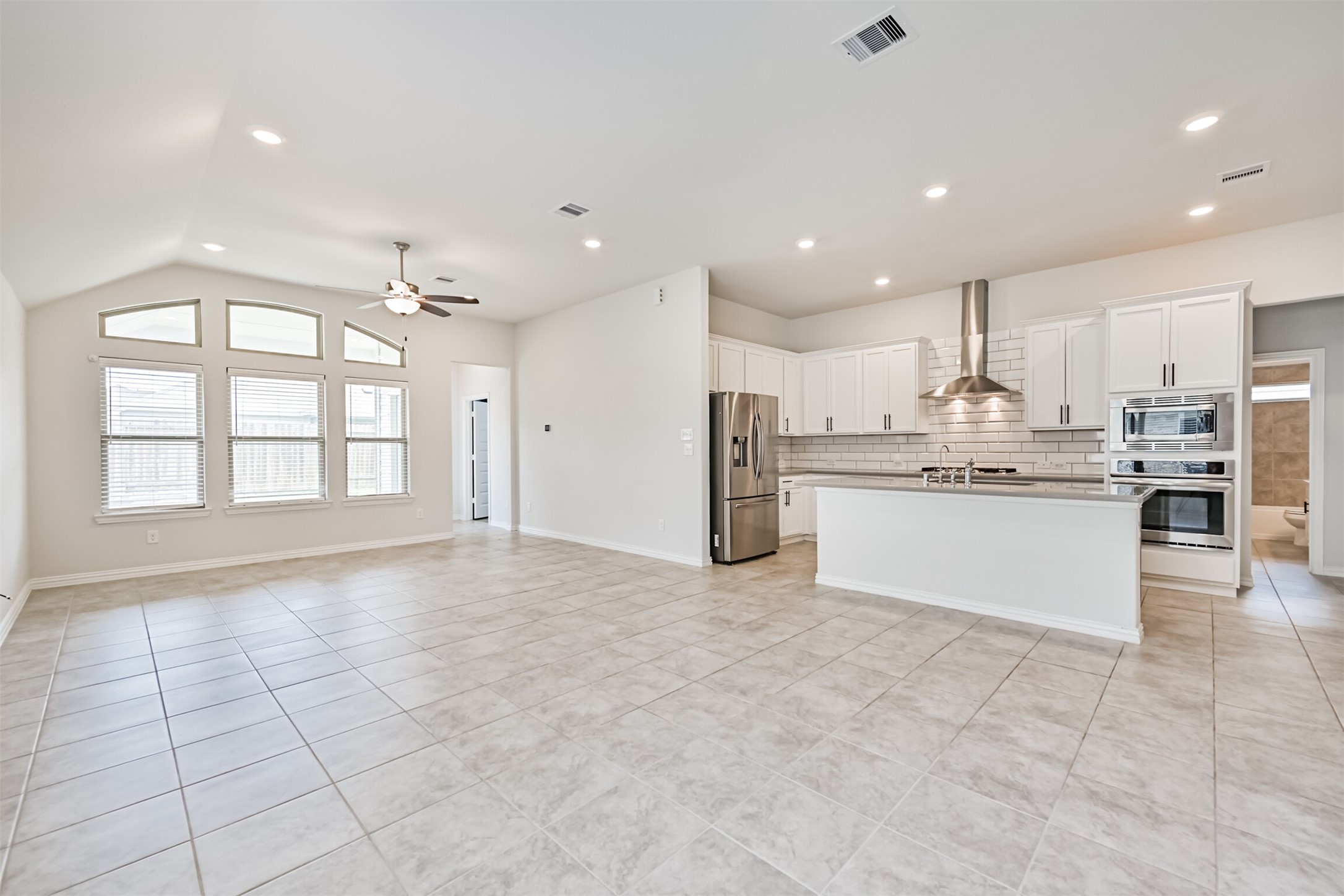 7019 Terra Drive Manvel, TX 77578 - Photo 19 of 41 a large white kitchen with stainless steel appliances granite countertop a large stove top oven a sink and dishwasher