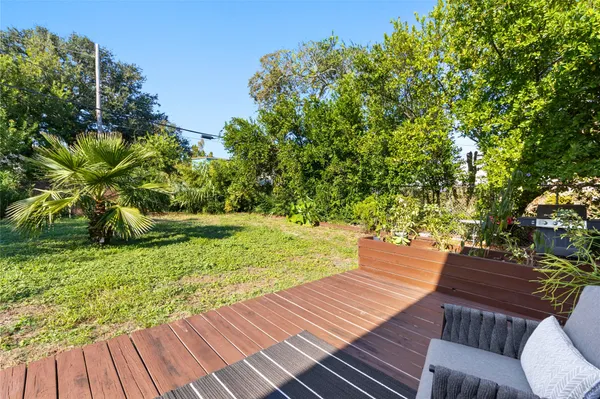 a view of yard from deck with patio