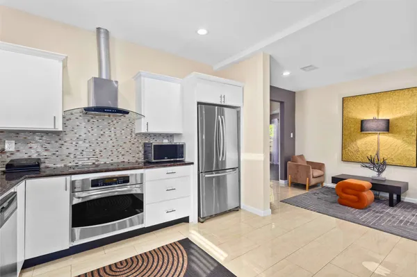 a kitchen with stainless steel appliances granite countertop a stove a sink and a refrigerator