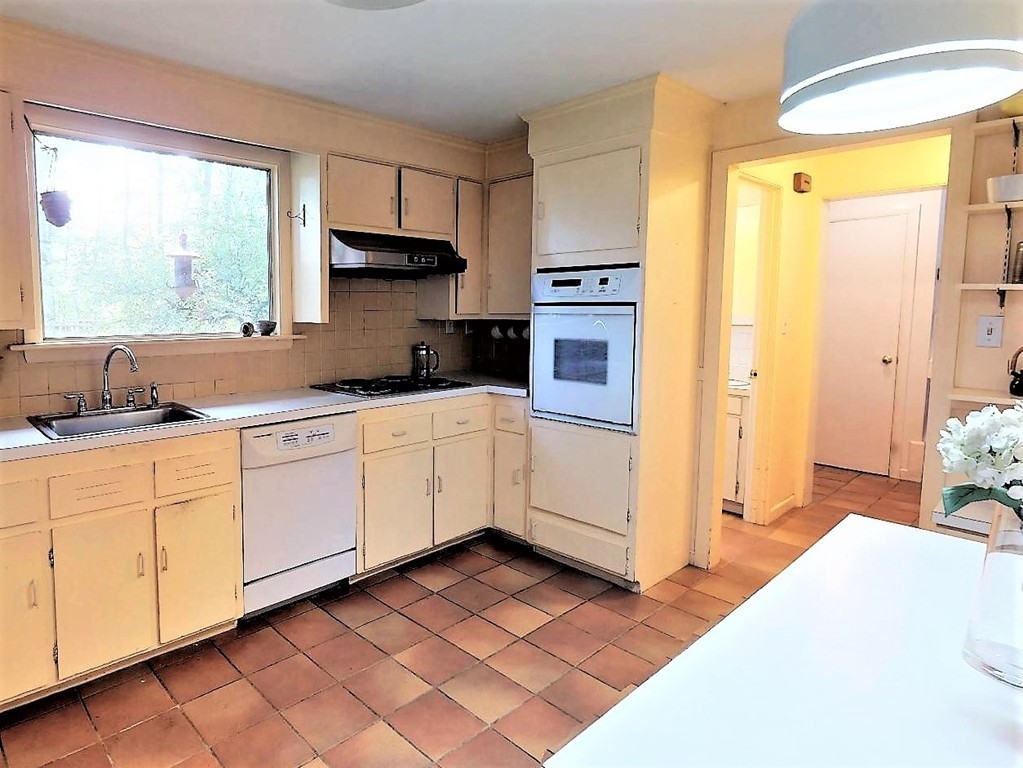 63 Lakeshore Road Natick, MA 01760 - Photo 15 of 30 a kitchen with granite countertop a sink cabinets stainless steel appliances and a window