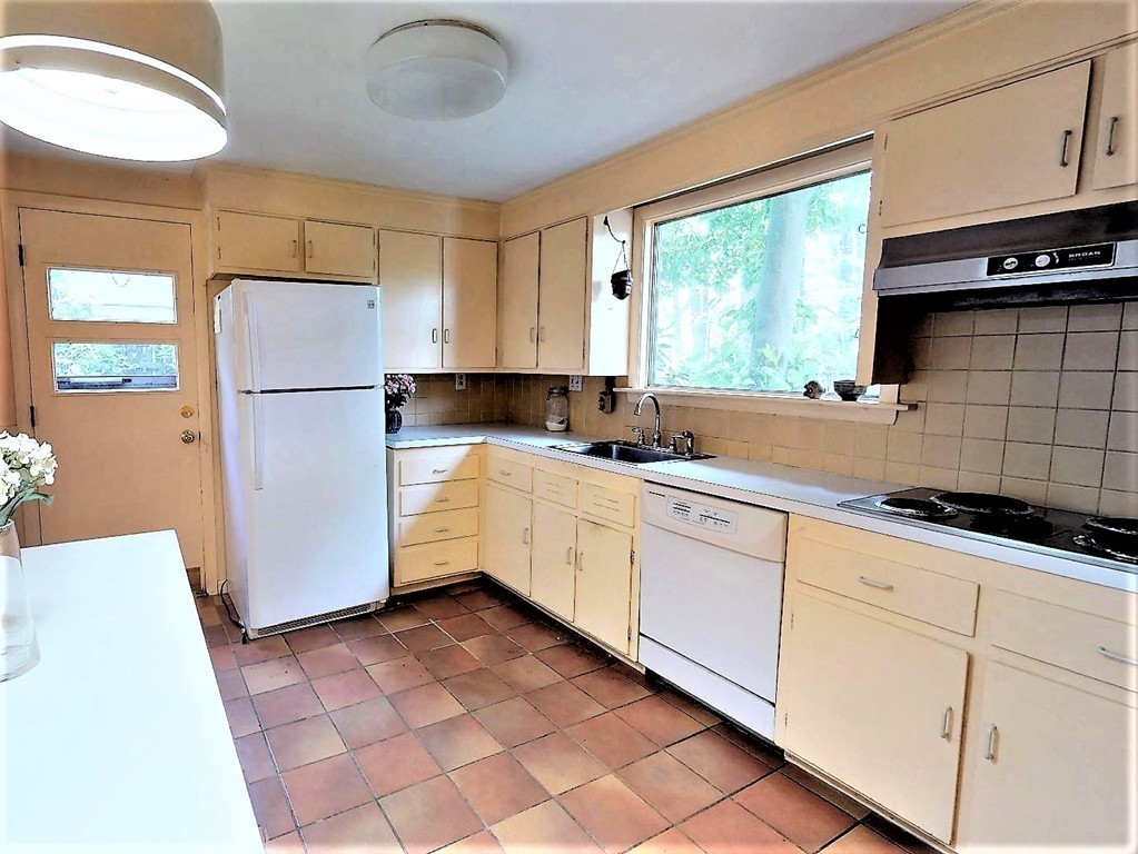 63 Lakeshore Road Natick, MA 01760 - Photo 16 of 30 a kitchen with granite countertop a refrigerator a sink a stove a microwave and cabinets