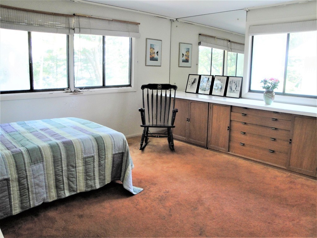 63 Lakeshore Road Natick, MA 01760 - Photo 20 of 30 a spacious bedroom with a bed a table and windows