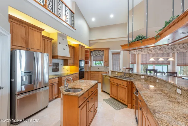 a kitchen with granite countertop a stove a sink and a refrigerator