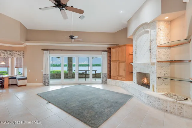 a view of a livingroom with a fireplace and chandelier fan