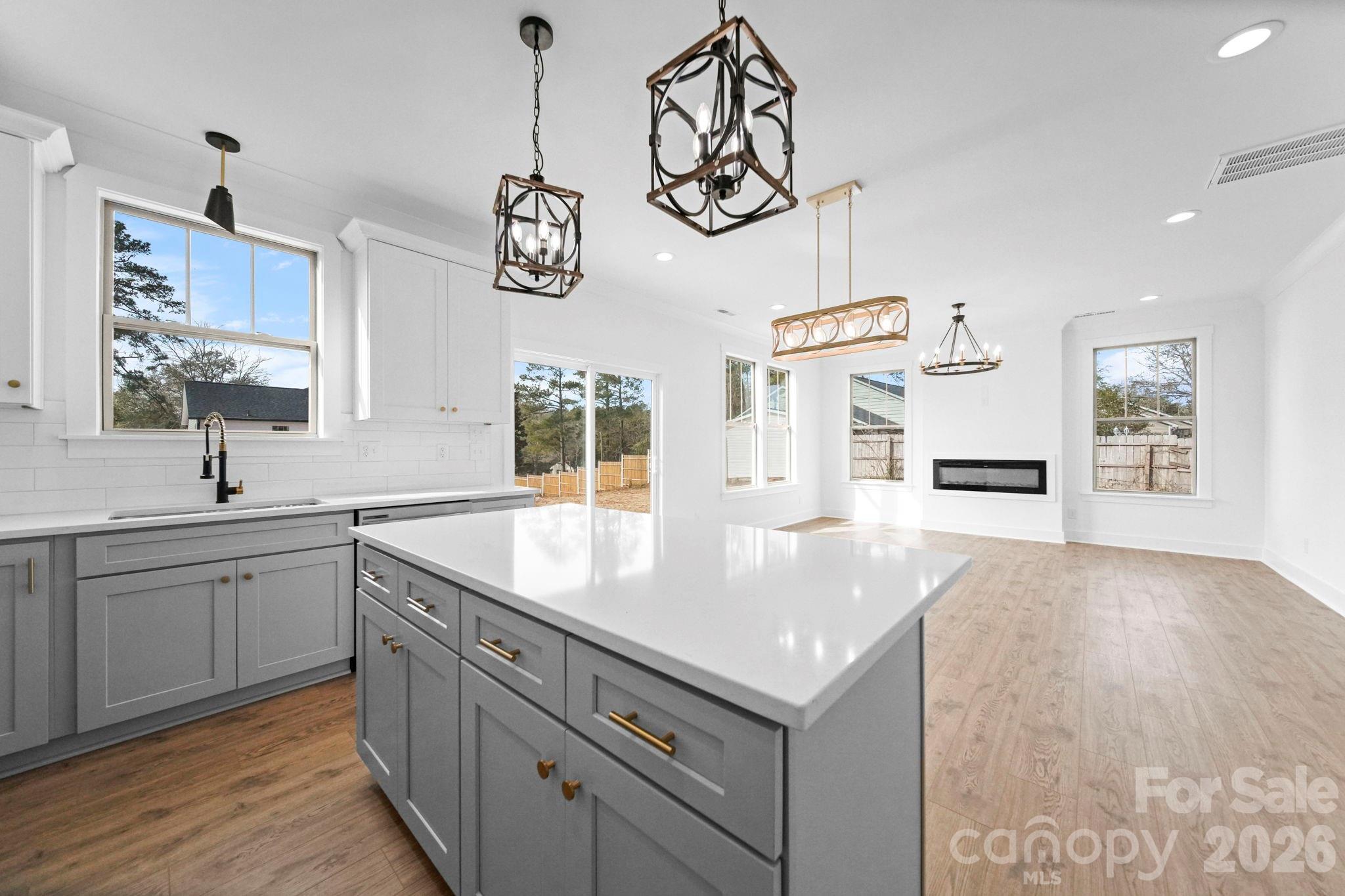 1220 Morven Road Wadesboro, NC 28170 - Photo 2 of 17 a kitchen with a sink chandelier and wooden floor
