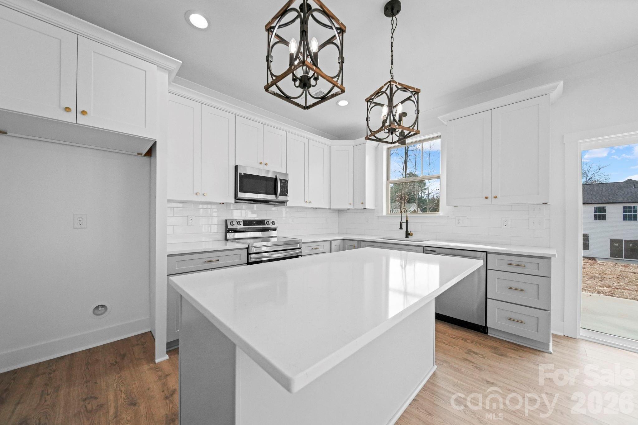 1220 Morven Road Wadesboro, NC 28170 - Photo 3 of 17 a kitchen with stainless steel appliances granite countertop a sink a stove and refrigerator