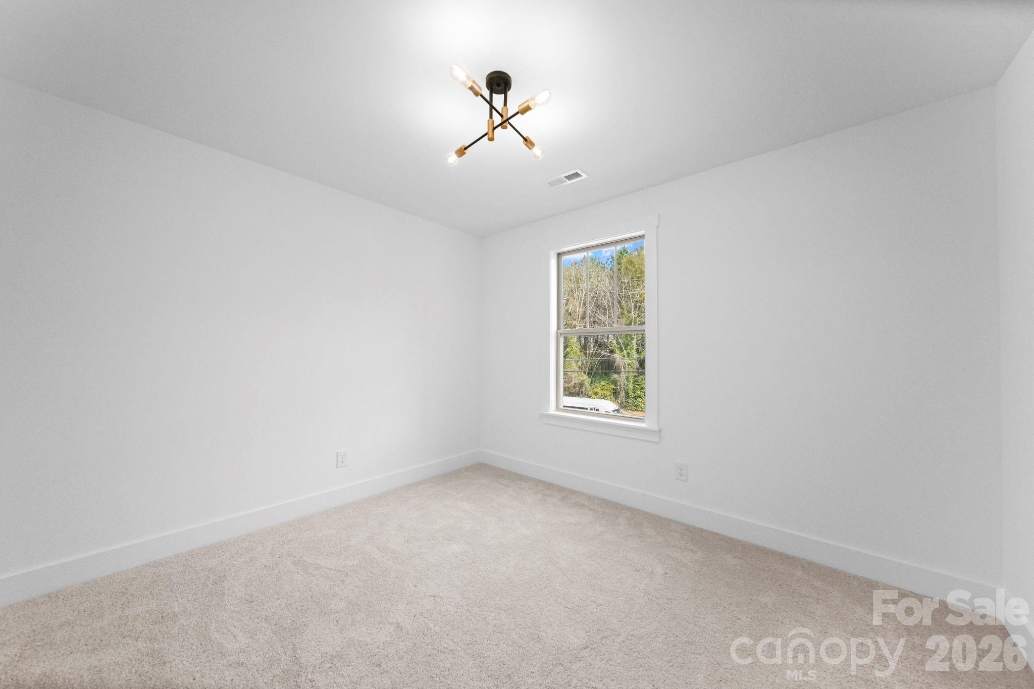 1220 Morven Road Wadesboro, NC 28170 - Photo 9 of 17 an empty room with ceiling fan and window