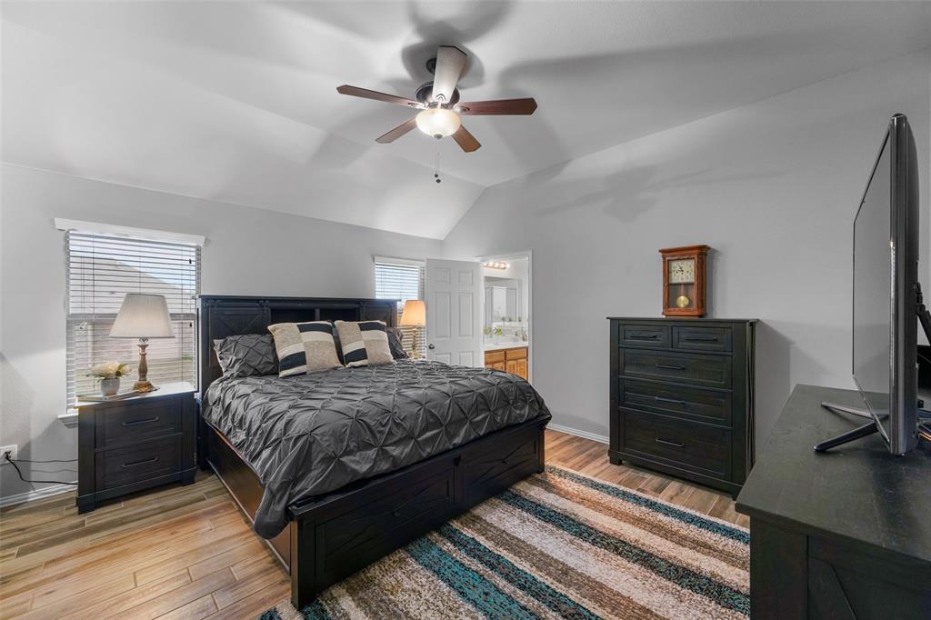 102 Avery Lane Fate, TX 75189 - Photo 13 of 30 a bedroom with a bed and a chandelier