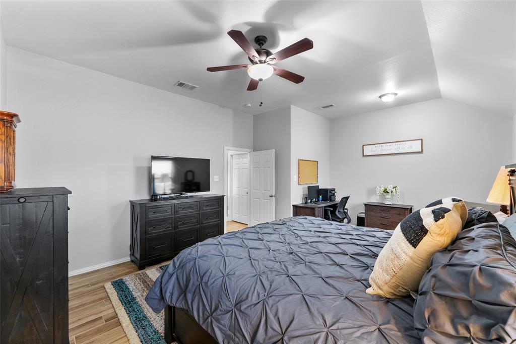 102 Avery Lane Fate, TX 75189 - Photo 14 of 30 a bedroom with a bed and a television