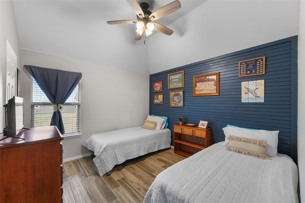102 Avery Lane Fate, TX 75189 - Photo 18 of 30 a bedroom with two beds and a chandelier