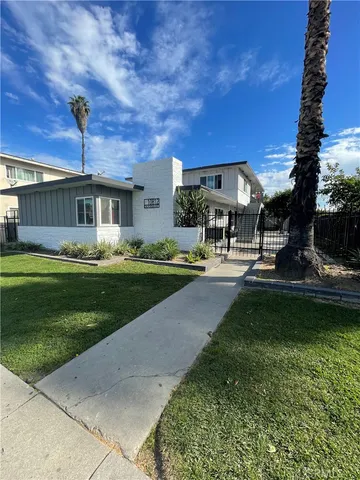 a front view of a house with garden and trees