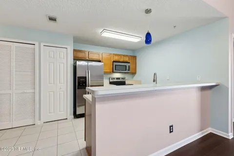 a kitchen with a sink a refrigerator and cabinets