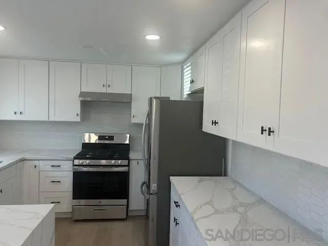 a kitchen with stainless steel appliances a refrigerator stove and cabinets