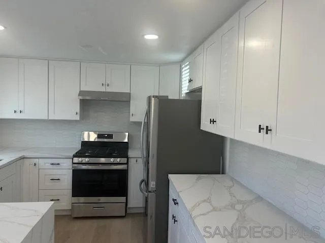 a kitchen with stainless steel appliances a refrigerator stove and cabinets