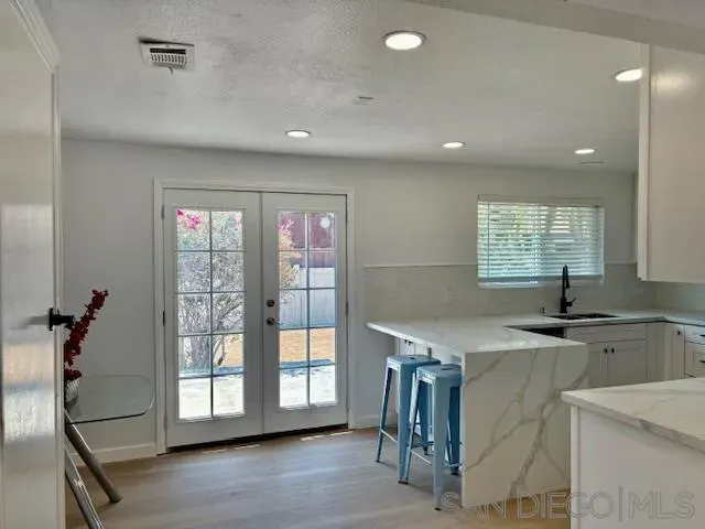 a kitchen with granite countertop a stove a sink and a refrigerator