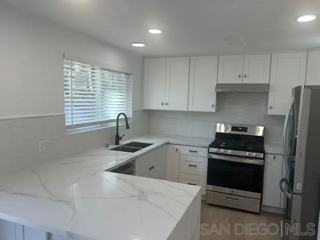 13520 Carriage Road Poway, CA 92064 - Photo 2 of 19 a kitchen with granite countertop a stove a sink and a refrigerator