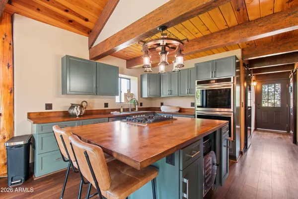 a kitchen that has a stove and a wooden floor