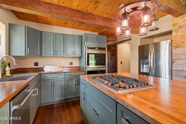 a kitchen with stainless steel appliances granite countertop a sink a stove and wooden floors