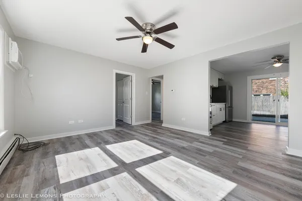 an empty room with wooden floor and ceiling fan