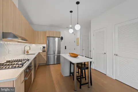 a kitchen with stainless steel appliances a table chairs and a refrigerator