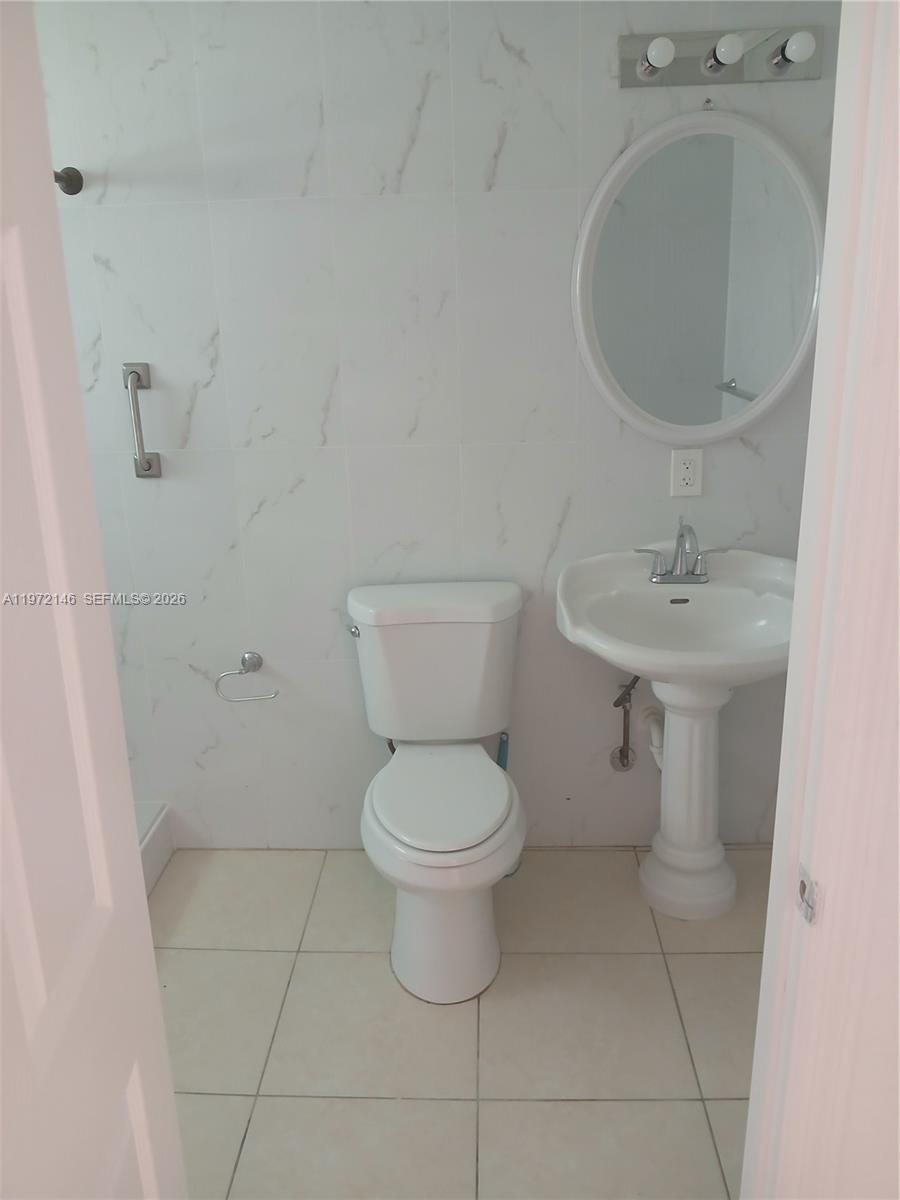 6471 Southwest 27th Street, Unit 2 Miramar, FL 33023 - Photo 28 of 41 a bathroom with a toilet sink and mirror