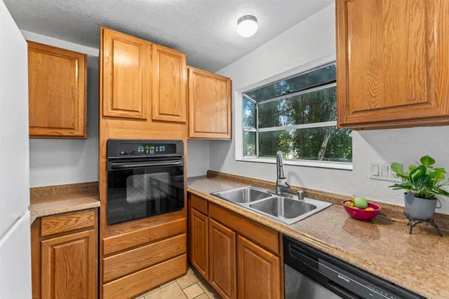 a kitchen with granite countertop a sink and a stove