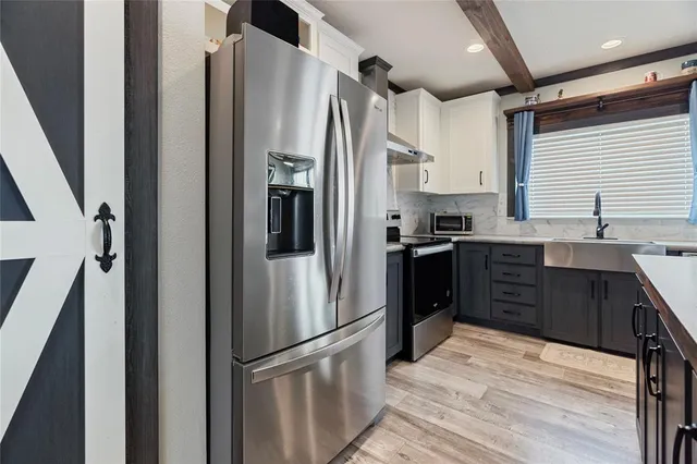 a kitchen with stainless steel appliances granite countertop a sink a stove and a wooden floors