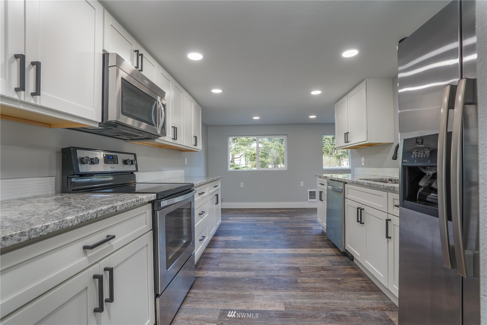 8126 Canyon Road East Puyallup, WA 98371 - Photo 19 of 37 a large kitchen with stainless steel appliances granite countertop a stove top oven a sink and dishwasher