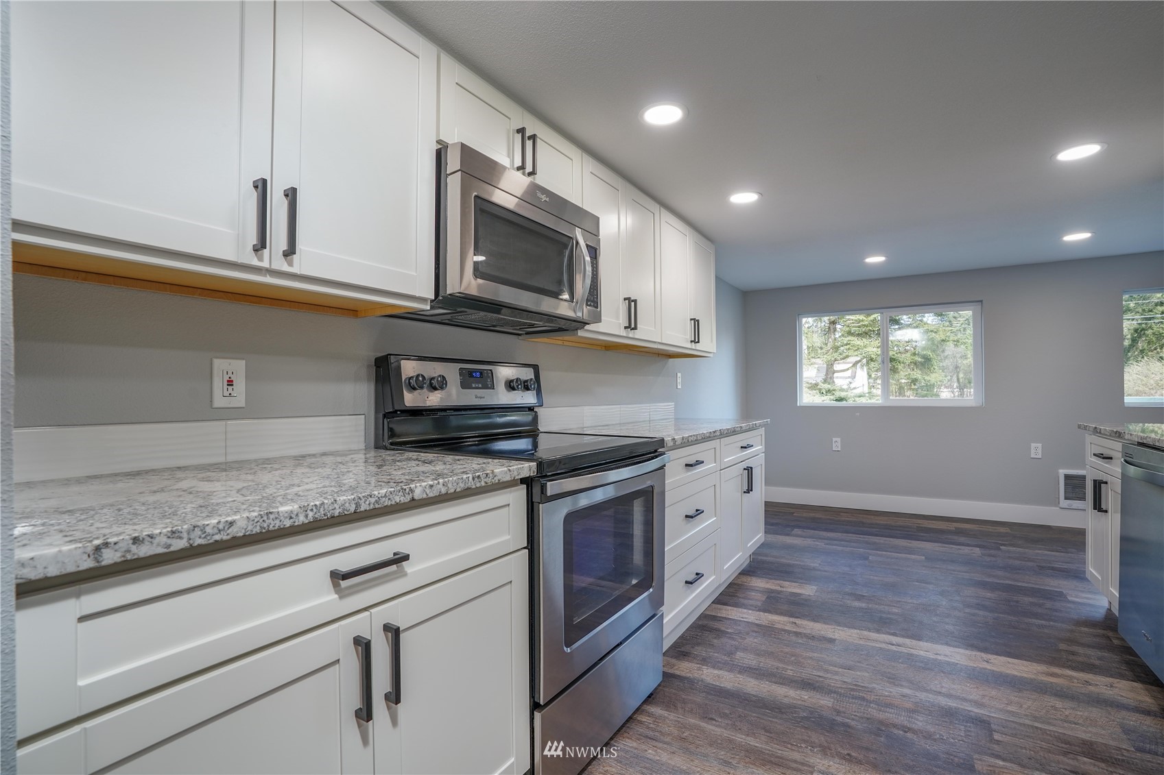 8126 Canyon Road East Puyallup, WA 98371 - Photo 21 of 37 a large kitchen with stainless steel appliances granite countertop a stove a sink and a microwave