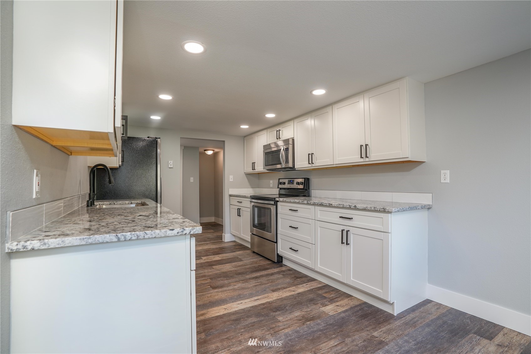 8126 Canyon Road East Puyallup, WA 98371 - Photo 22 of 37 a kitchen with stainless steel appliances granite countertop a sink stove and cabinets