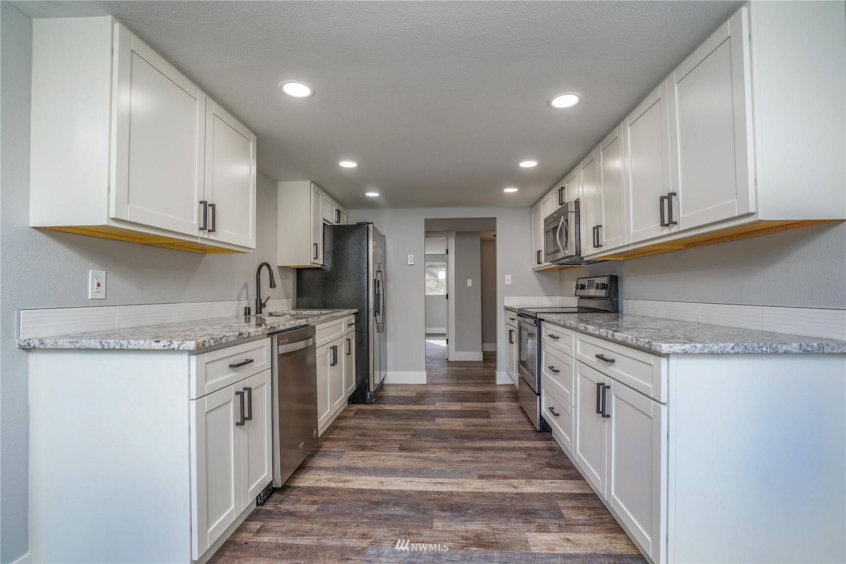 8126 Canyon Road East Puyallup, WA 98371 - Photo 23 of 37 a large kitchen with stainless steel appliances granite countertop a lot of counter space and a sink