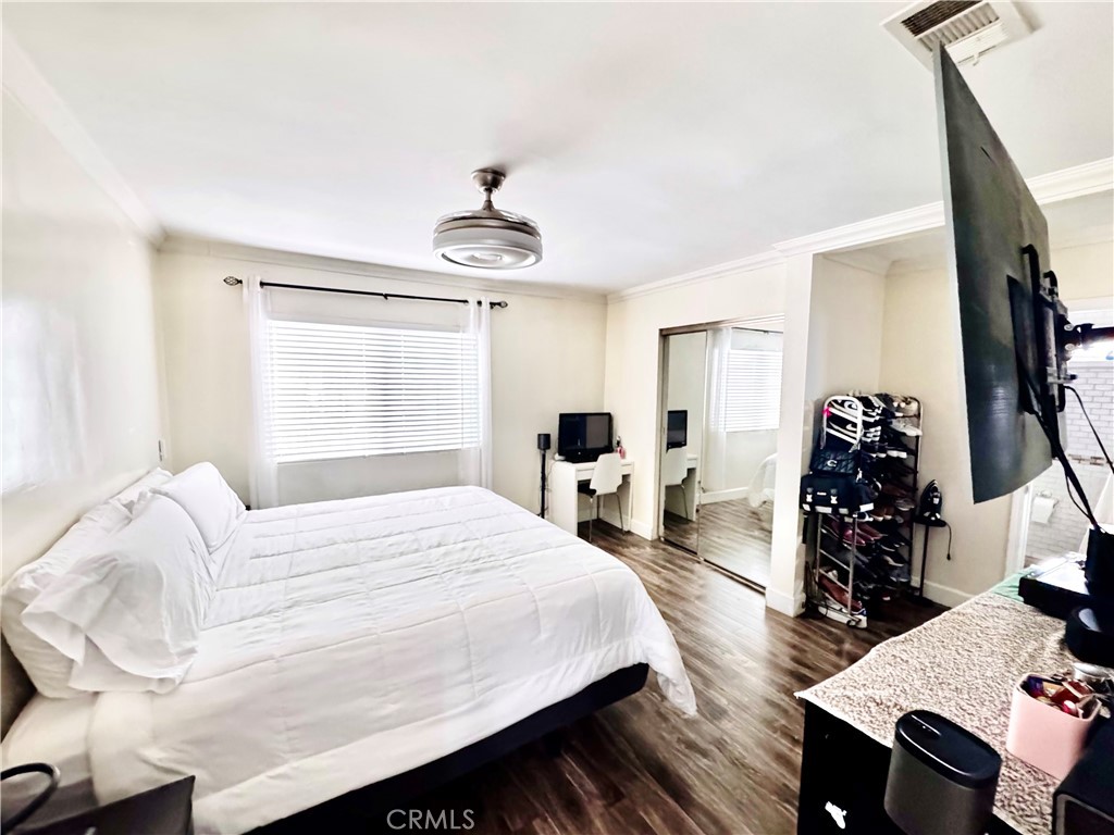 10152 Stanwin Avenue Arleta, CA 91331 - Photo 16 of 42 a bedroom with a bed and wooden floor