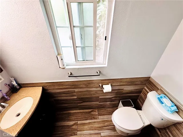 a bathroom with a toilet a sink and a mirror