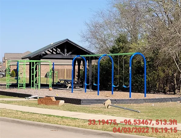 a view of a building with large trees and plants