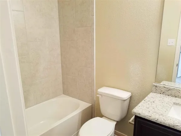 a white toilet sitting next to a bath tub