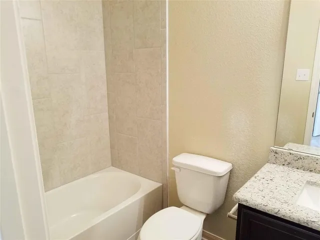 a white toilet sitting next to a bath tub