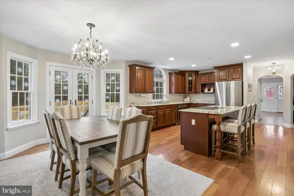 a view of a dining room with furniture a chandelier and wooden floor