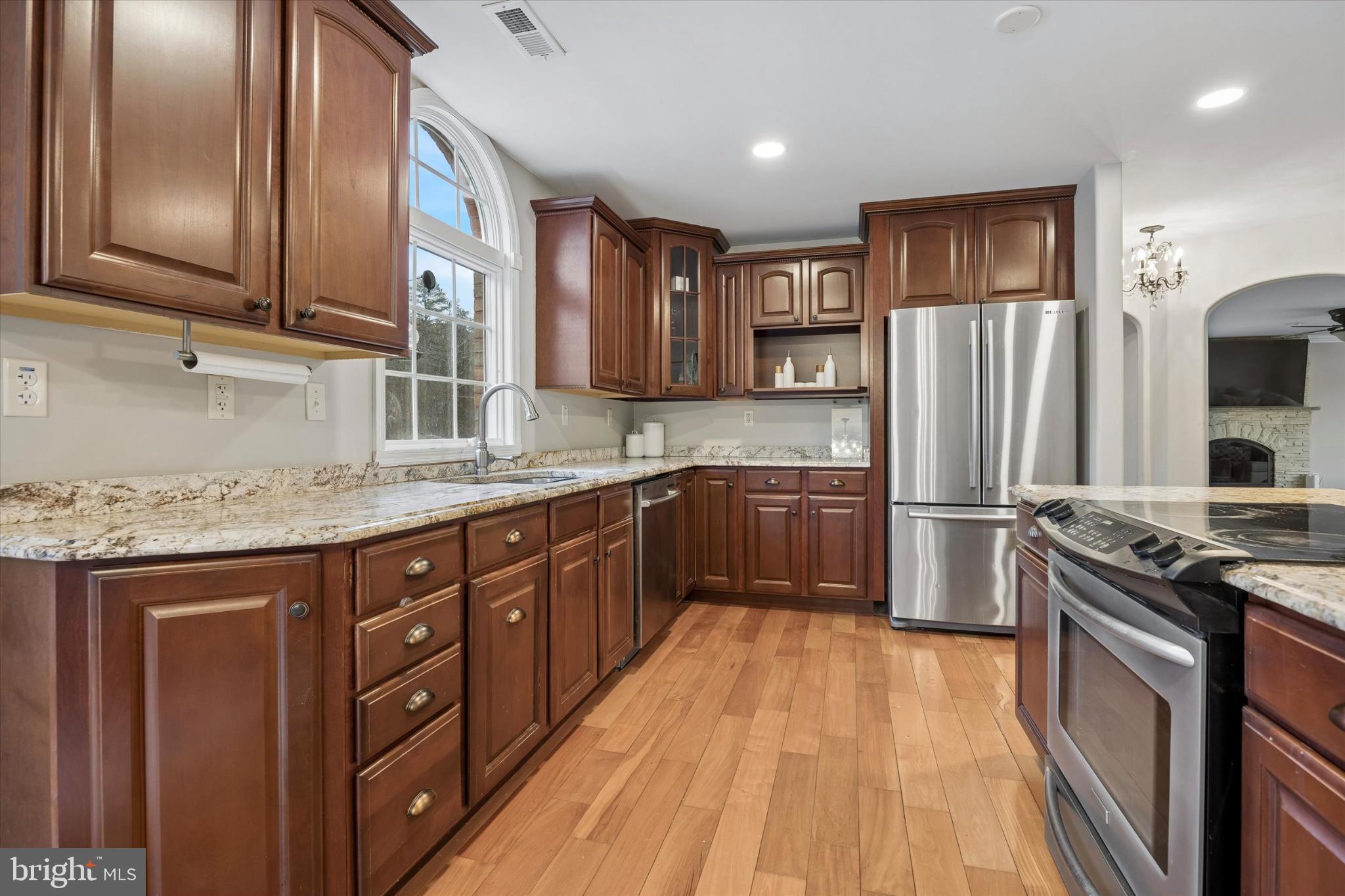883 Atsion Road Shamong, NJ 08088 - Photo 14 of 42 a kitchen with stainless steel appliances granite countertop a stove a sink dishwasher a refrigerator and cabinets with wooden floor