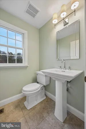 a bathroom with a sink toilet and a mirror