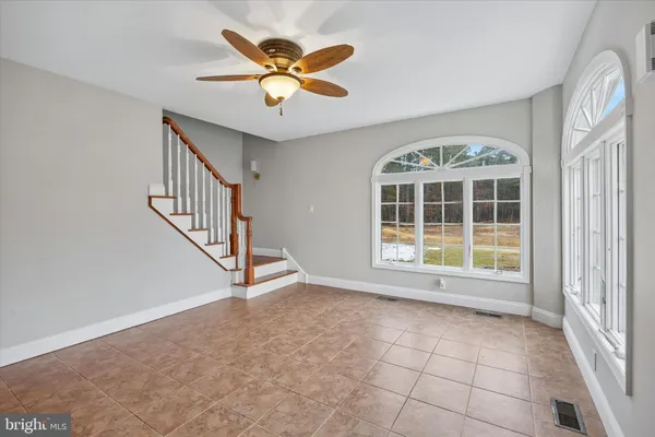 an empty room with windows and fan