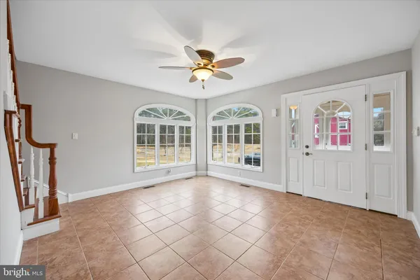a view of an empty room with a window and a ceiling fan