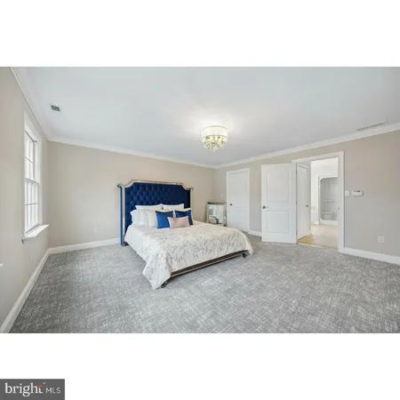 a bedroom with a bed and a large mirror